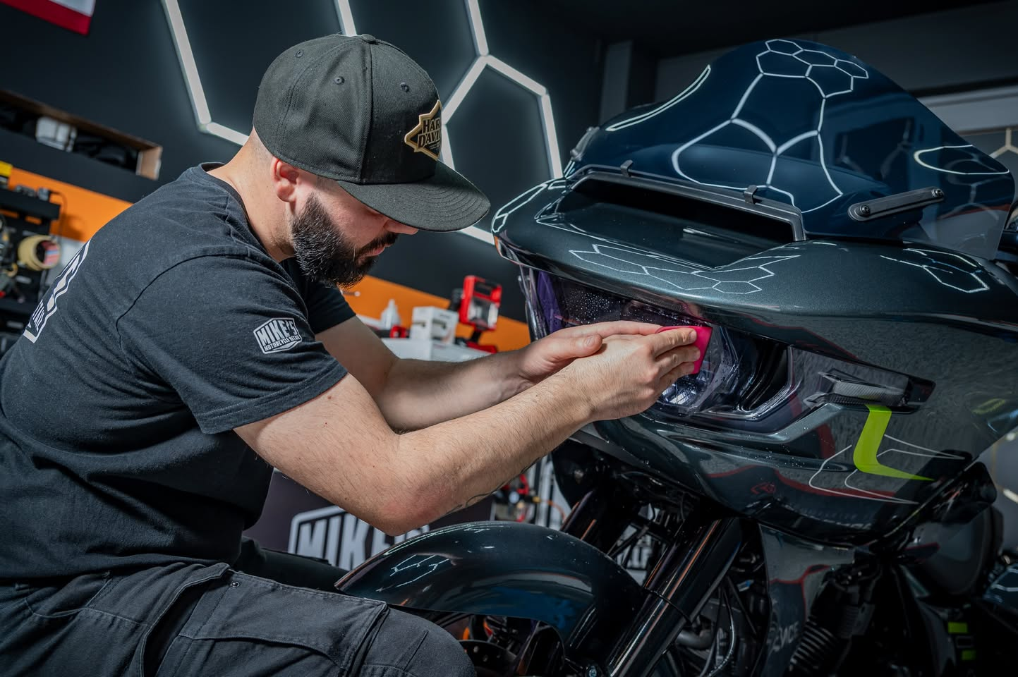 Michele applica un trattamento sul faro di una Harley-Davidson